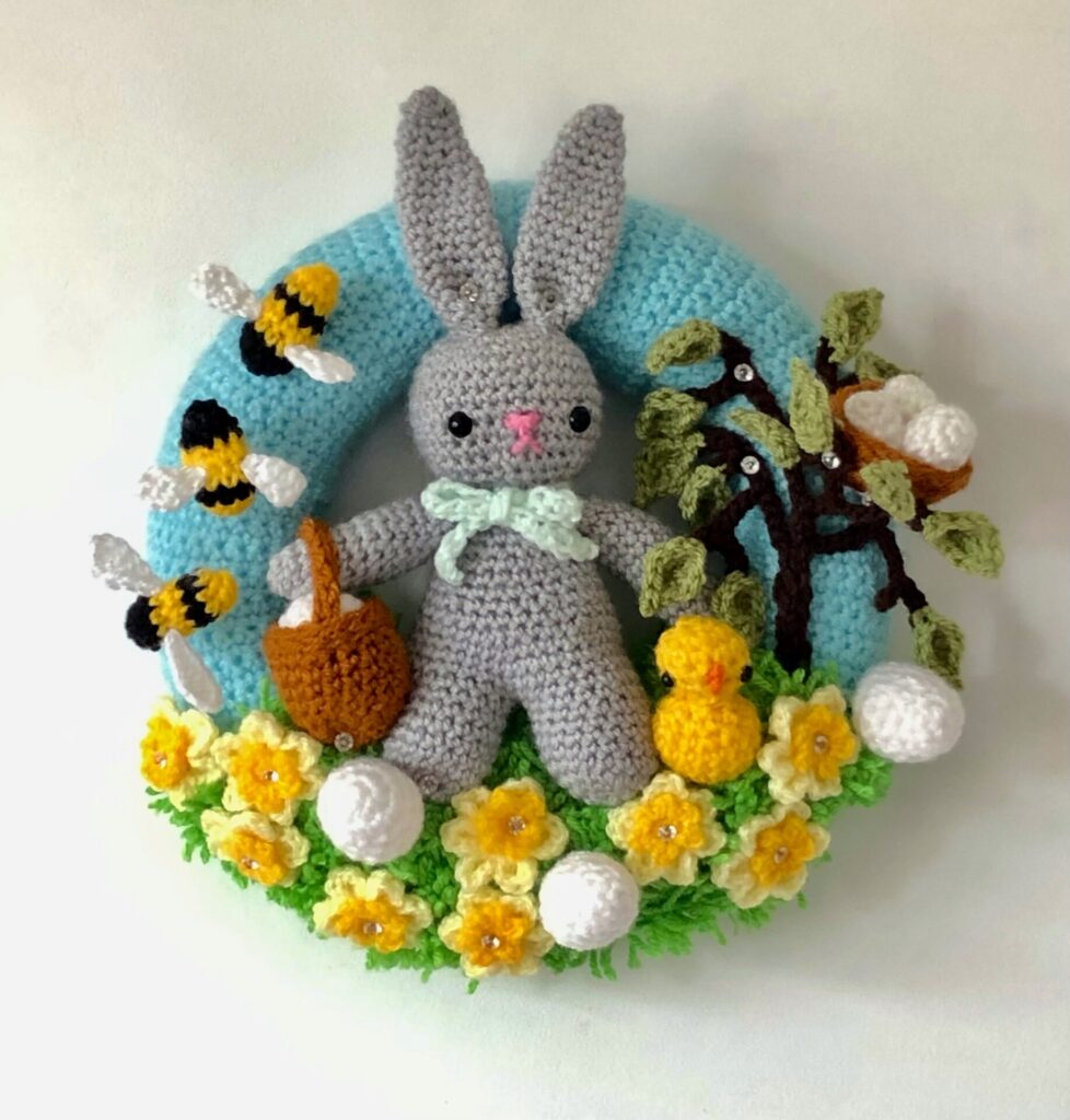 crocheted wreath, with a rabbit. daffodils, bees chick and eggs