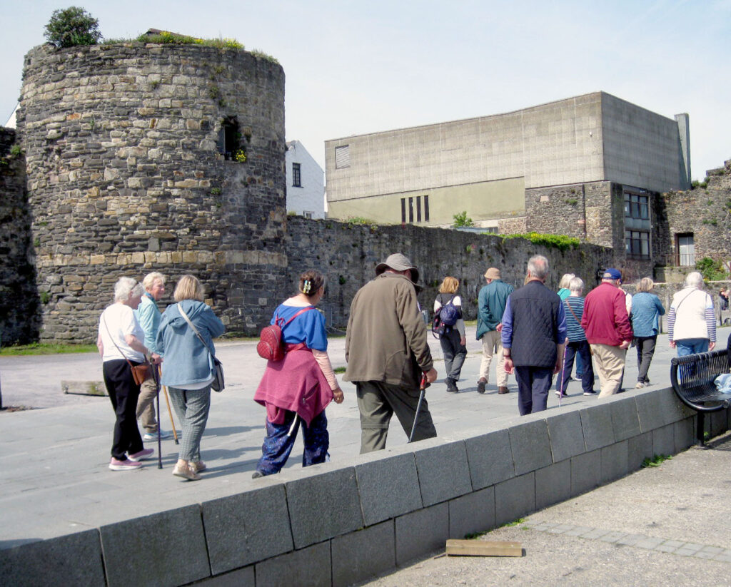 old tower, people walking, modern building