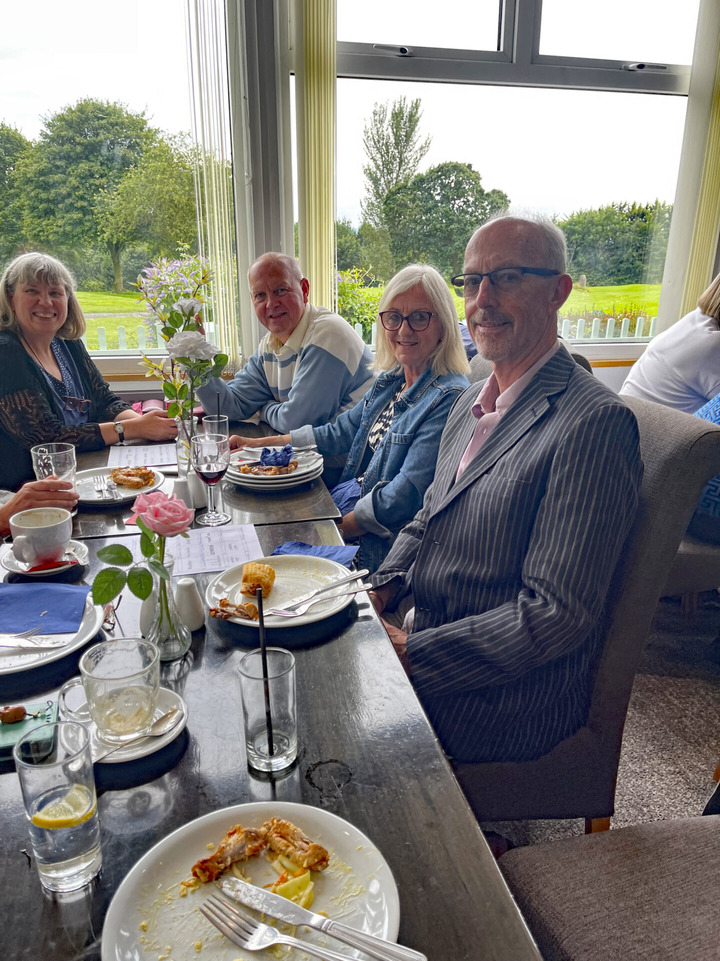 people, table, plates of food, glasses,