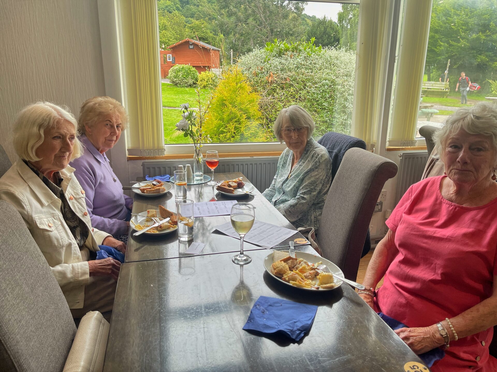people, table, plates of food, glasses,