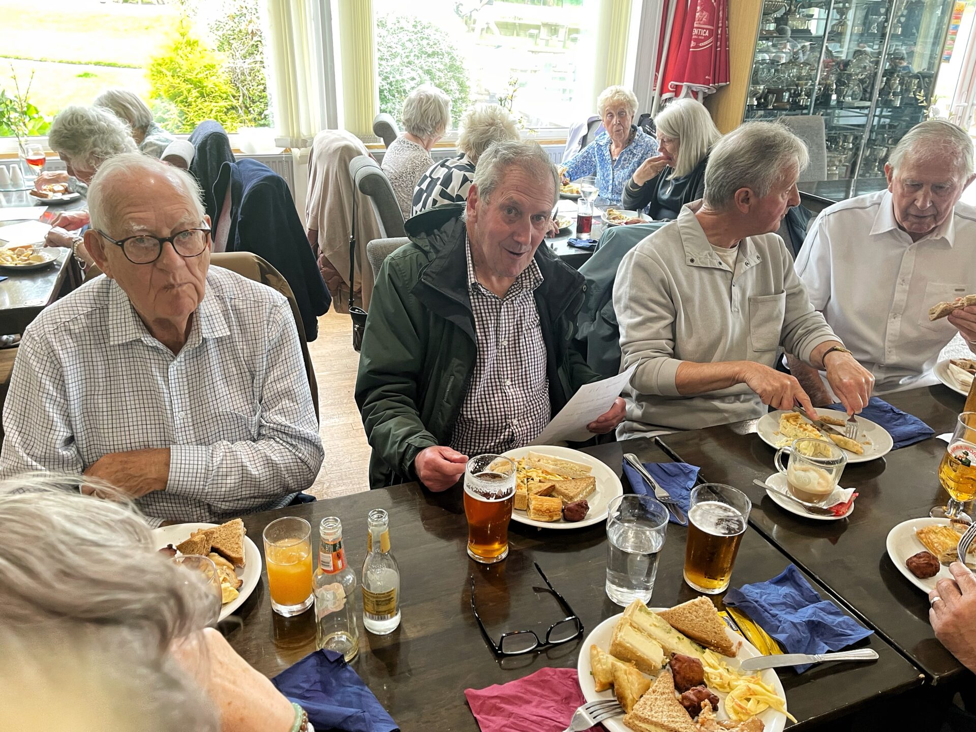 people, table, plates of food, glasses,