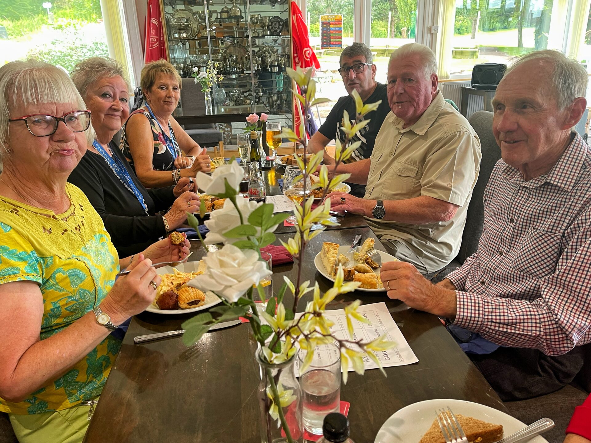 people, table, plates of food, glasses,