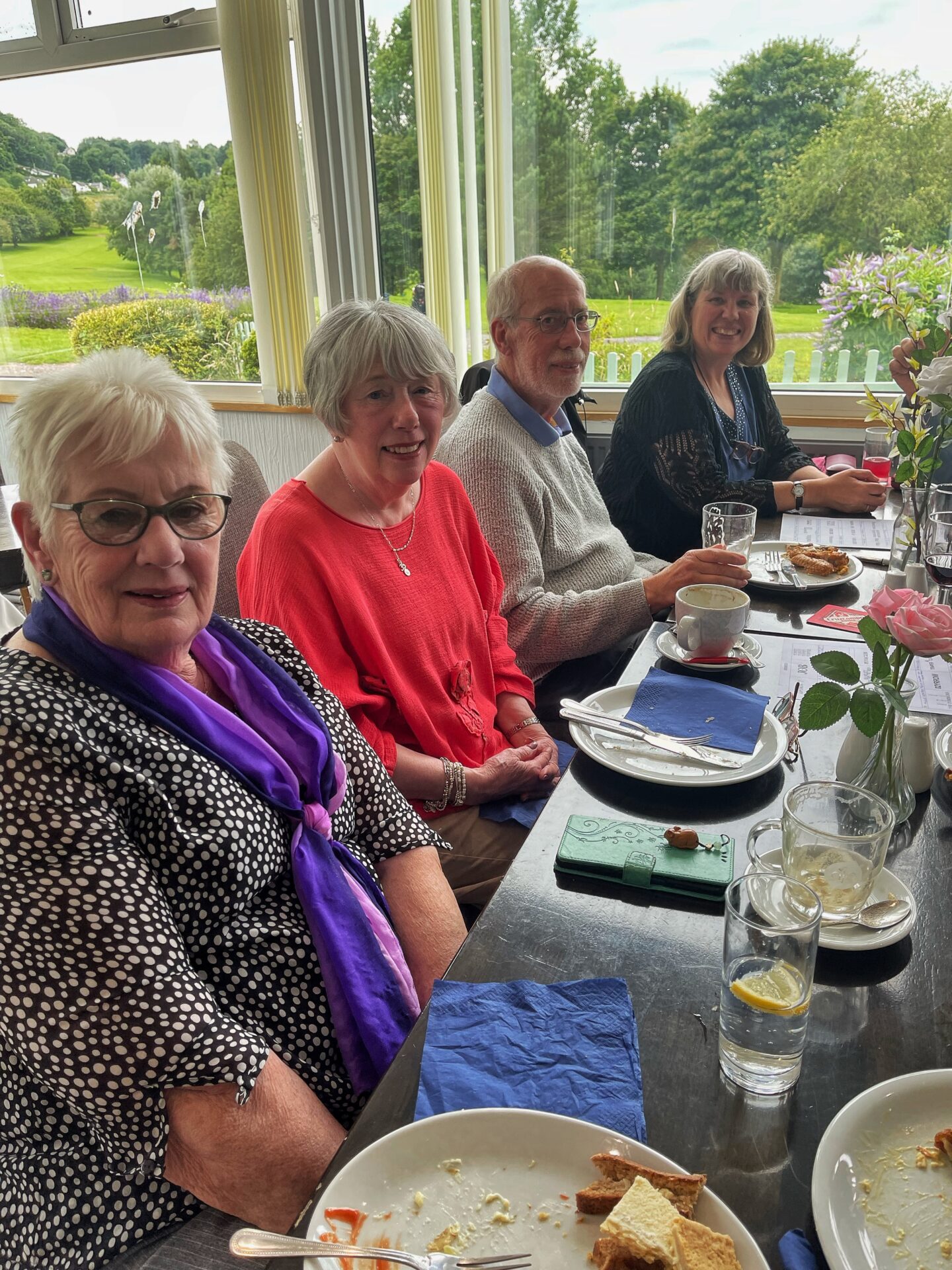 people, table, plates of food, glasses,